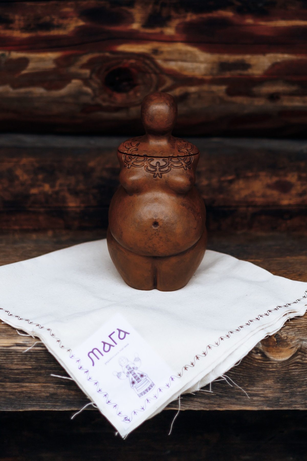 Sculpted clay MAGA candle on an embroidered cloth